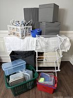 Lot showing overall organizing items including cubes, hangers, laundry baskets, containers, drying rack, and watering can.