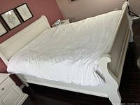 Full assembled view of white sleigh bed frame showing headboard, footboard, side rails and mattress area.