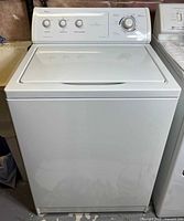 Front full view of washer showing closed lid and steel cabinet