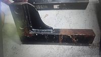 Close-up image of a 6-inch drop shank towing hitch showing front and side profiles with visible signs of wear and use, featuring a square tube and reinforced bracket.