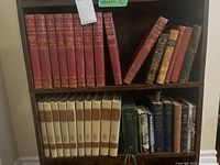 Image of multiple shelves of hardcover vintage books with red and beige spines, including The University Society The Great Ideas Program volumes and various other titles.
