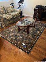Carpet laid on wooden floor with sofa, glass coffee table, and exercise bike visible for size context