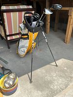 Yellow and grey Callaway Hyper-Lite stand bag with clubs attached, view from front showing bag and one leg extended