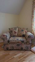 Front view of the oversized floral armchair showing upholstery and cushions.