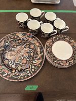 Full set overview showing platter, plates, cups on table surface