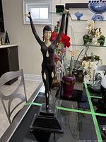 Front view of sculpture on glass table showing full figure and base