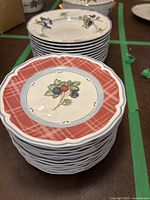 Stack of red-bordered berry plates in front and light-colored berry plates behind
