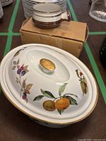 Oval Royal Worcester serving dish with lid showing fruit and floral decoration and gold trim.