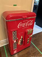 Side view of the red Coca Cola plastic vintage cooler showing front graphics and top.