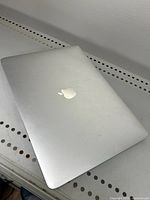 Closed silver Apple MacBook Pro laptop showing smudges and light wear on top lid and aluminum body.