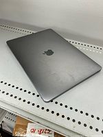 Closed Apple MacBook Pro 13-inch showing space gray color and light wear on the outer lid.