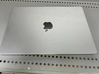 Closed Apple MacBook Pro 15-inch laptop showing minor surface scratches on aluminum lid with Apple logo.