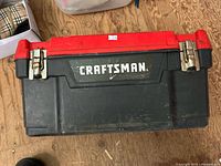 Closed Craftsman toolbox showing red lid with black base and metal latches.
