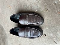 Top view of brown leather loafers showing minor scuffs and wear on the surface.