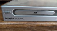 Front view of silver Medion DVD recorder showing power button, DVD tray with RW logo, and Medion branding.