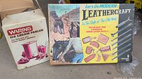 Two boxes side by side, Waring Ice Cream Maker box on left showing wear, Leathercraft Kit box with colorful western image on right
