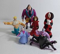 Photo showing six figurines: King Triton, Ursula, Evil Stepmother, Fairy Godmother, Cruella De Vil, and a male character in purple suit (likely John Ratcliffe).