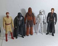 Five Star Wars vintage action figures arranged side by side, front facing view showing Obi Wan Kenobi, Darth Vader, Chewbacca, Stormtrooper, Anakin Skywalker in that order.