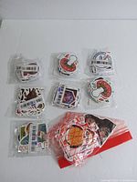 Eight packages of stickers sealed in plastic including different themes such as mushroom stickers, cartoon stickers, NASA, and other designs.