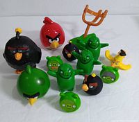 Twelve Angry Birds and pig figures along with a green catapult launcher. Characters include Bomb, Red Bird, Terence, Minion Green Pigs, Leonard the Pig, Big Red Bird, Chuck Launcher, and two Mega Fling toys.