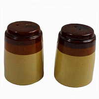 Side view of the two rustic stoneware shakers, showing the brown and tan color scheme and cylindrical shape.