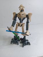 General Grievous figure standing holding blue and green lightsabers, showing overall condition and detail