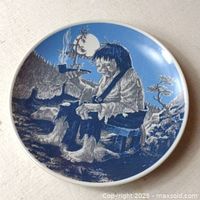 Top view of the collector's plate showing a sitting troll smoking a pipe in a forest scene under moonlight, rendered in blue and white.