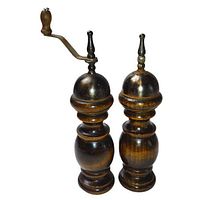 Front view of both mills standing upright showing wooden bodies and metal crank handles.