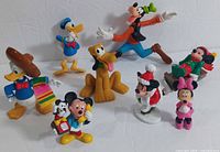 Lot of eight Disney PVC figures including Donald Duck in Mexican attire, Goofy, Minnie Mouse, Pluto, and multiple Mickey Mouse figures in various poses and costumes.