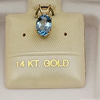 Close-up of pendant showing the marked 14K gold sign beneath the blue topaz gemstone.