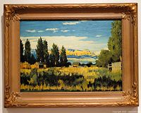 Front view of the framed oil painting depicting a vibrant landscape with trees, cabins, and mountains.
