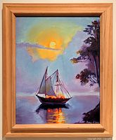 Frontal view of framed oil painting depicting sailboat on water with sunset and tree. Shows signature and date in lower right corner.