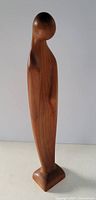 Full front view of carved teak Madonna modernist sculpture showing smooth wood grain and rounded head shape.
