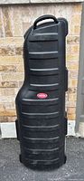 Front view of black SKB hard shell golf bag travel case showing ribbed protective surface and top handle