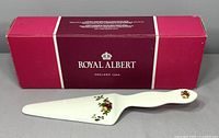 Porcelain cake server with floral rose pattern in front of original Royal Albert box