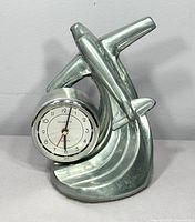 Front view showing airplane design and clock face with brand Sarsaparilla on white dial