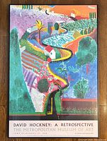 Full view of the framed David Hockney exhibition poster with vibrant landscape artwork.