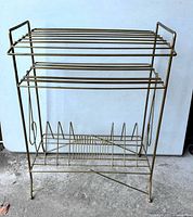 Front view of the vintage metal stereo record stand showing the multiple tiers and wireframe design.