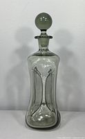 Full front view of the smoke glass decanter showing overall shape and spherical stopper