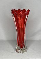 Front view of the red art glass vase showing full height and flared scalloped top edge with clear and red glass blending.