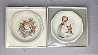 Two zodiac bone china bowls in original boxes, viewed from above showing Pisces and Aquarius designs, measuring 8.5 inches wide each.
