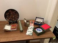 Overview of all items on a table including Chinese cloisonne balls, cloisonne egg, bone chopsticks, and Chilean copper plate with boxes.