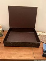 Open decorative carved wooden box on table