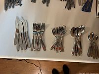 Full spread of flatware laid out on white surface
