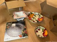 Photo showing Holiday Season round glass platter in box, two Gibson Everyday China pieces (salad bowl and plate) with fruit motif, and Temp-Tations Bead bakeware in front.