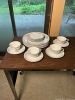 Full set including four dinner plates, four dessert plates, four teacups, and four saucers arranged on a table