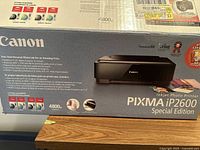 Box front and side view showing Canon PIXMA iP2600 printer branding, specifications and features in English and Spanish.