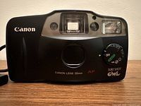 Front view of Canon Sure Shot Owl Prima AF8 film camera showing lens, flash, and mode dial