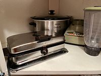 Photo shows Toastess sandwich maker, Rival slow cooker, and Osterizer blender together on countertop.