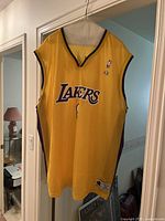 Front view of yellow Lakers basketball jersey with number 8 and Champion and NBA logos.